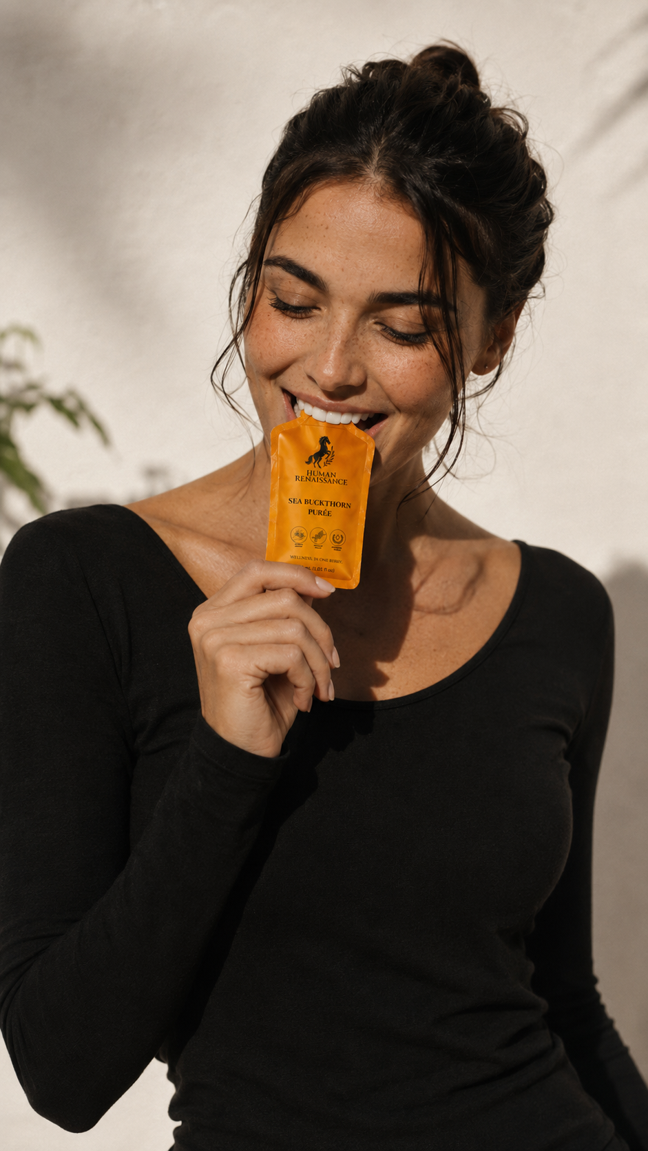 Smiling woman holding a Sea Buckthorn Puree pouch