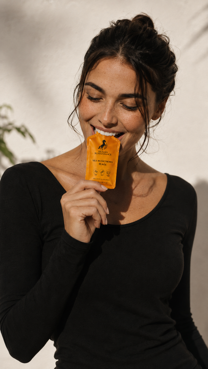 Smiling woman holding a Sea Buckthorn Puree pouch