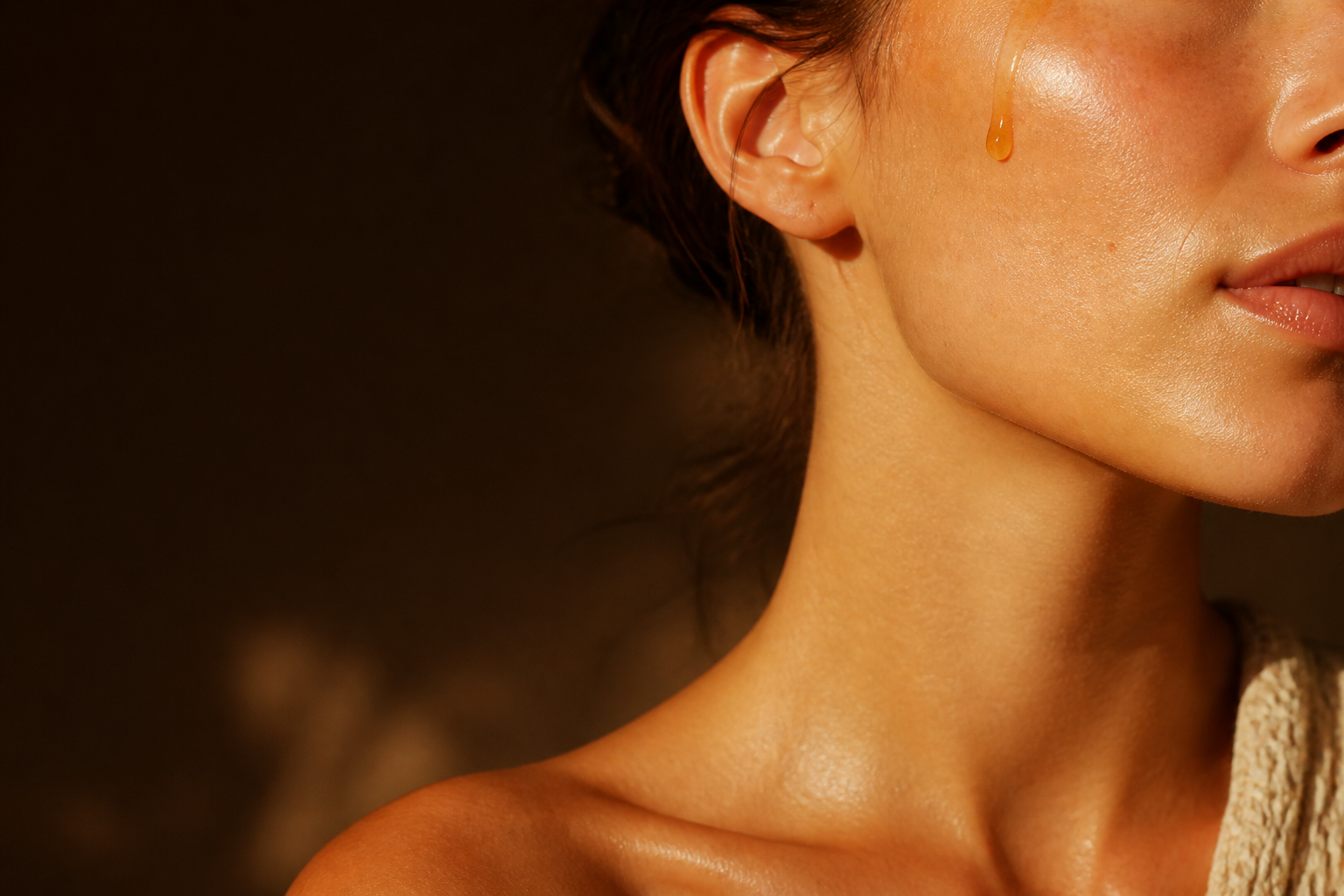 Warm beauty close-up with a golden puree droplet on skin